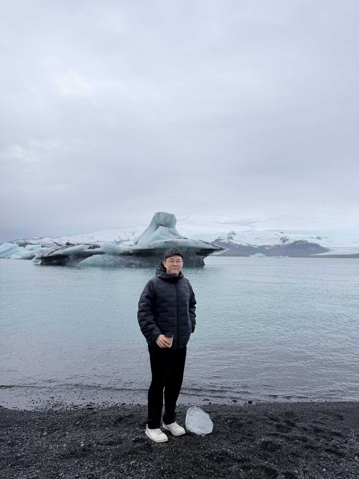 Bryan Chua standing beside a glacial lagoon in Iceland